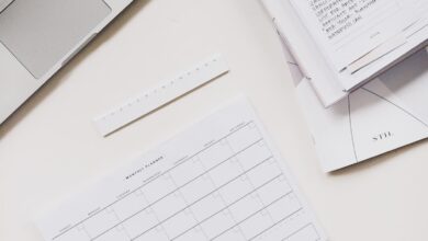 silver laptop computer near notebook