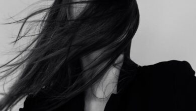 grayscale photography of woman wearing long-sleeved shirt